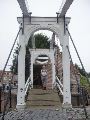 Een monumentale ophaalbrug die naar een molen leidt.