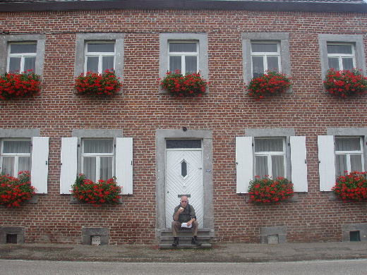 Knabbelend op een appel tussen de geraniums.