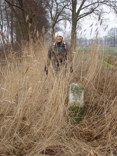 Grenspaal 514 schemerde tussen het riet.